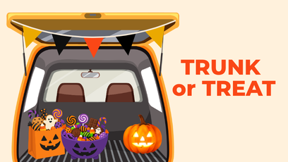 An open vehicle trunk with candy and pumpkins inside.