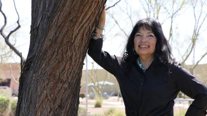 Dr. Natalie Ruiz Rivera leaning against a tree