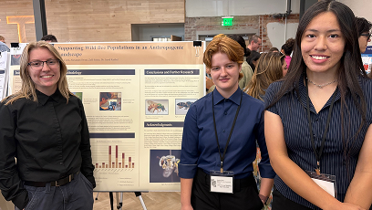 Alex, Arella, and Zalli standing near project poster board.
