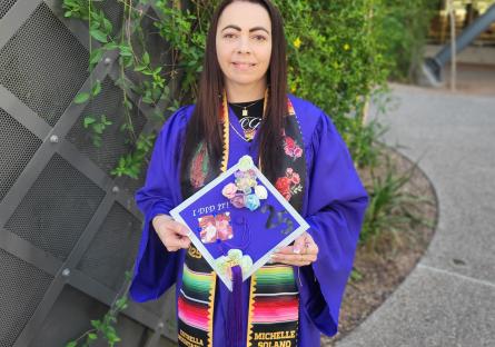 Michelle Solano poses with her decorated mortarboard 