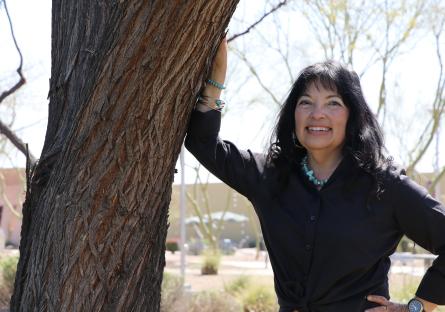 Dr. Natalie Ruiz Rivera leaning against a tree