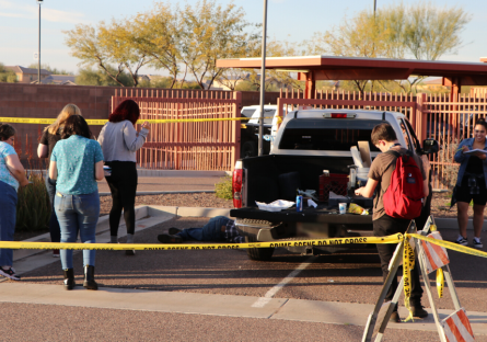 Students in parking lot navigating the mock crime scene.