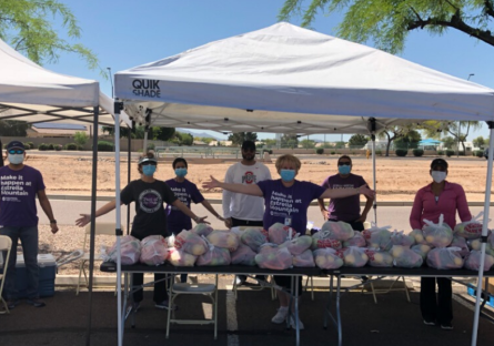 EMMC staff with outside tent or canopies servicing food from  St. Mary’s Food Bank.